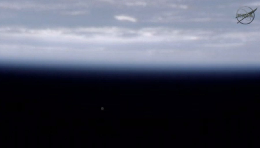 The private space capsule Dragon is visible as a small dot against the blackness of space in this view from International Space Station as the capsule flew by May 24.