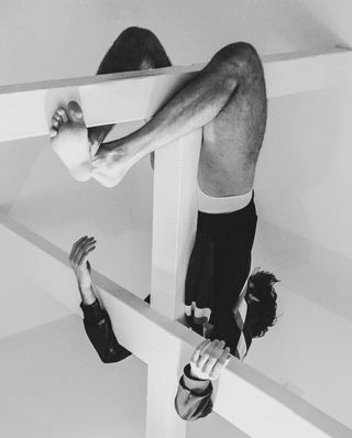 A man hangs upside down in a black and white image as seen in the art book Primal Sight by Efrem Zelony-Mindell