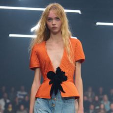 Model wears straight-leg patch-pocket jeans with peep-toe shoes on the Valentino SS26 runway.