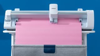 Cricut Venture everything you need to know; a white craft machine with large pink vinyl