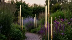 bullrush outdoor lighting in a pretty garden with a path and purple flowers