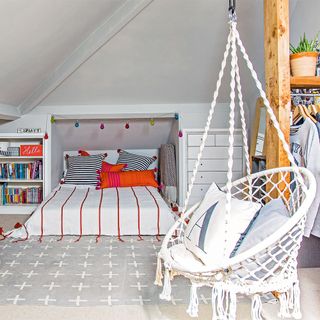 attic bedroom with hanging chair and bookshelf