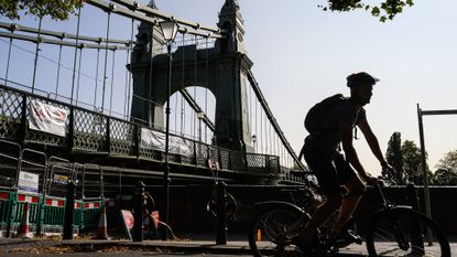 A cyclist negotiates the closed pathways around Hammersmith Bridge