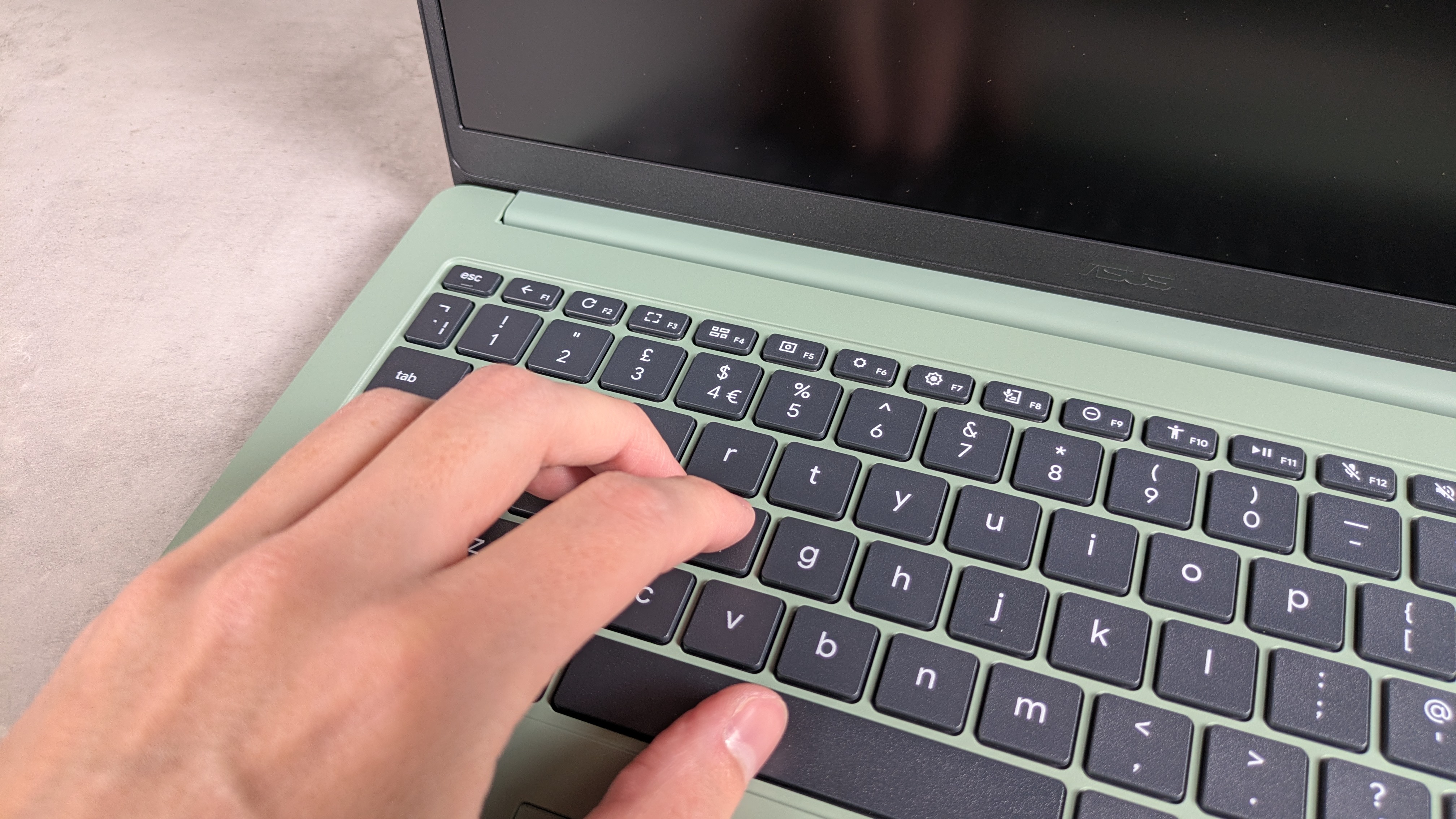 Hand typing on Asus Chromebook CX1505 on desk