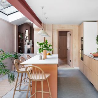 open plan kitchen with peach kitchen island on top of grey vinyl flooring