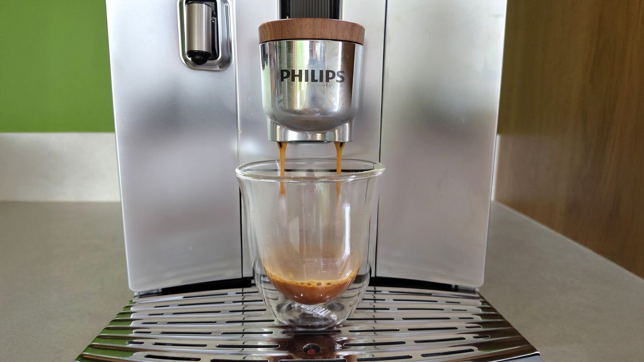 Philips Cafe Aromis Series 8000 coffee maker dispensing espresso into a glass cup