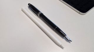 A photo of the Adonit Star stylus placed against the Apple Pencil on a white desk