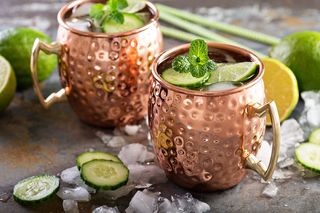 Two Moscow mule cocktails in copper mugs.