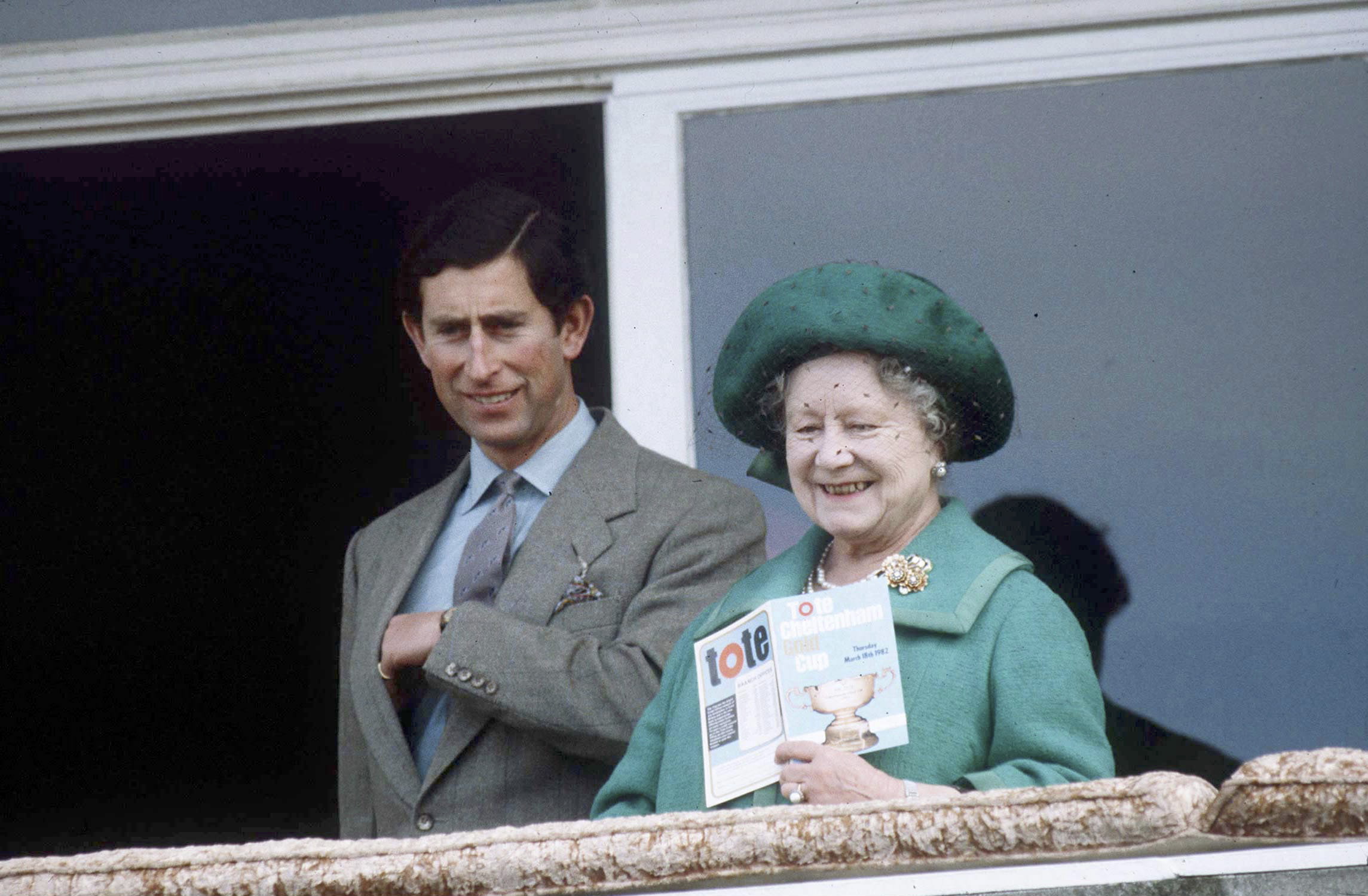 Queen Mother standing next to Prince Charles at the races