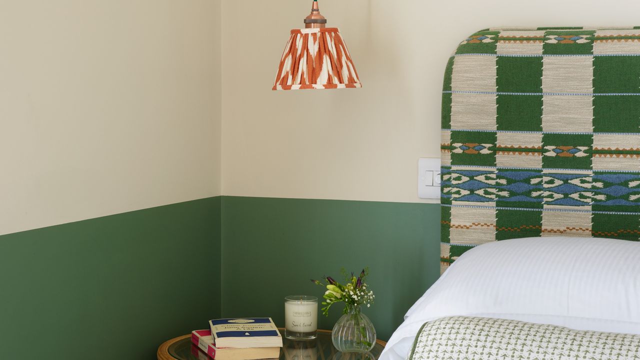 A bedroom with a two-tone paint effect and a pendant light