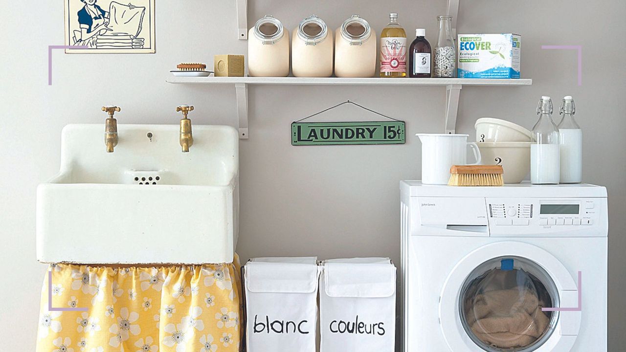 Laundry room with a sink, colour-code laundry baskets and a washing machine to support expert advice on the surprising place you should keep your laundry basket