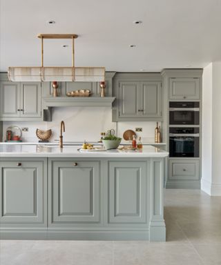 Grey kitchen with a gold statement pendant light above the island