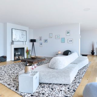living room with white walls grey sofa and wooden flooring