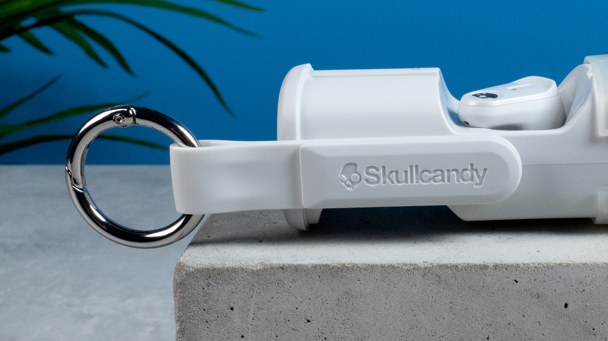 the skullcandy x bose method 360 anc earbuds in white, with a long charging case, a carabiner clip, and various silicone tip sizes