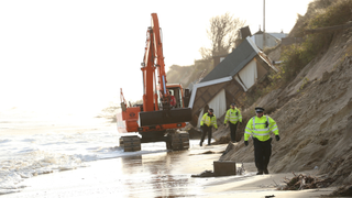 House slides down dune