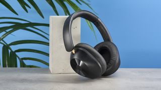 a pair of black bluetooth headphones made by OneOdio Focus A5 is photographed against a blue background