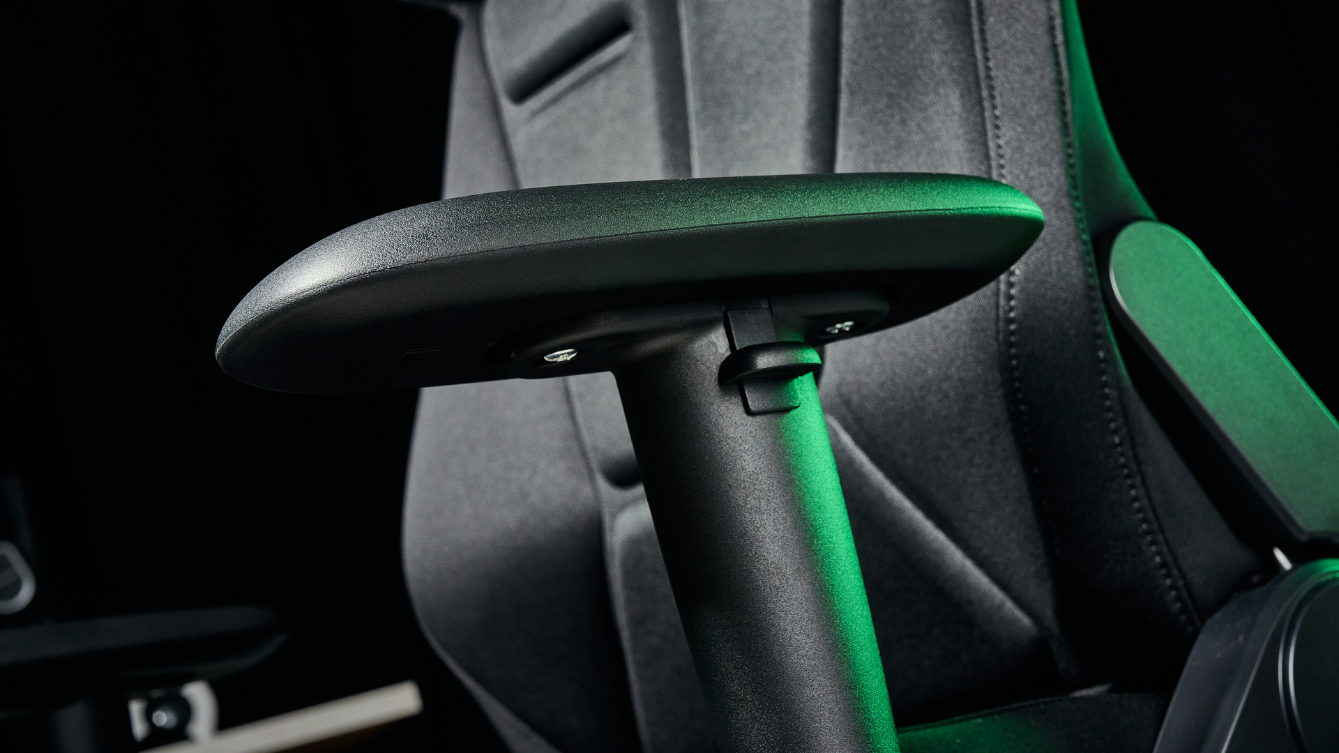 The Razer Soma Chroma chair's armrests, illuminated with a green glow