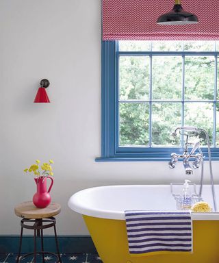 Bathroom with blue painted window frames and yellow painted bath