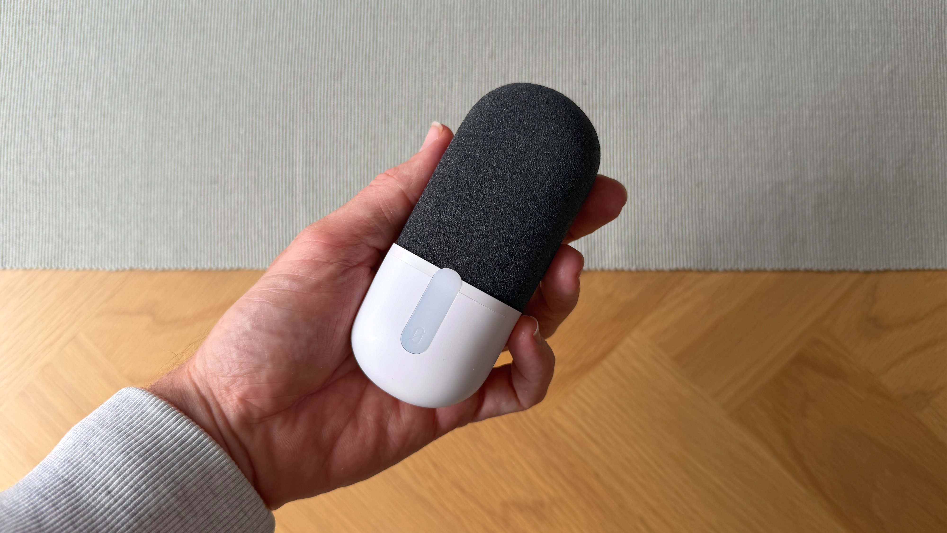 A reviewer holding the Elgato Wave Neo in front of the camera