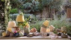 outdoor garden table filled with outdoor printed lampshades and stacks of plates