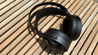 The FiiO FT3 over-ear headphones in black on a wooden surface.