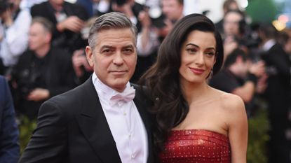 George Clooney and Amal Alamuddin embrace on the red carpet.