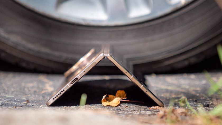 The gold Honor Magic V5 tented in front of a car tire