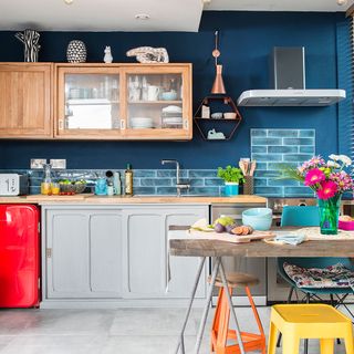 kitchen with teal green walls wooden worktop and kitchen chimney