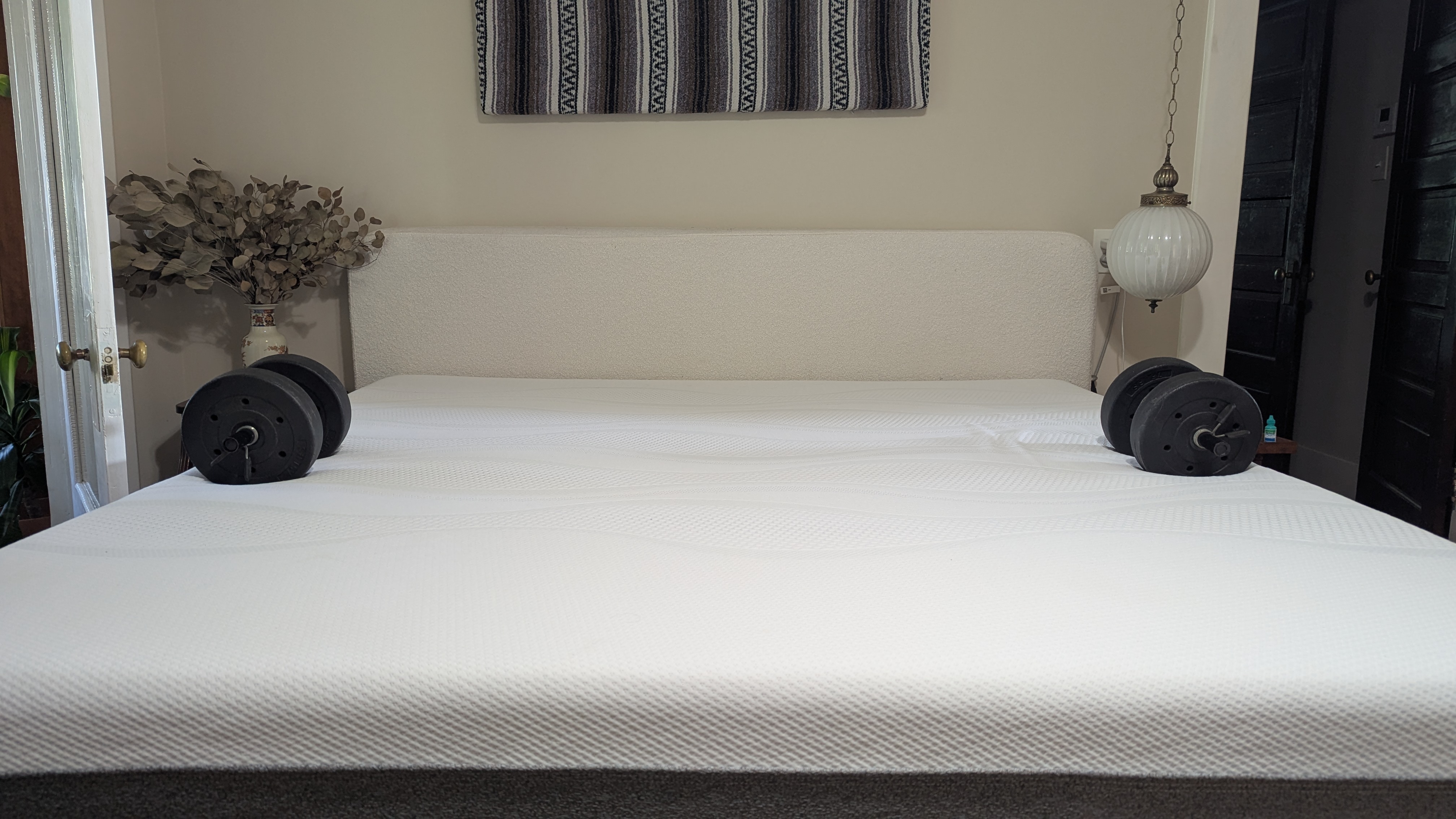 Two dumbbells placed on either edge of Sleep Number i8 smart mattress