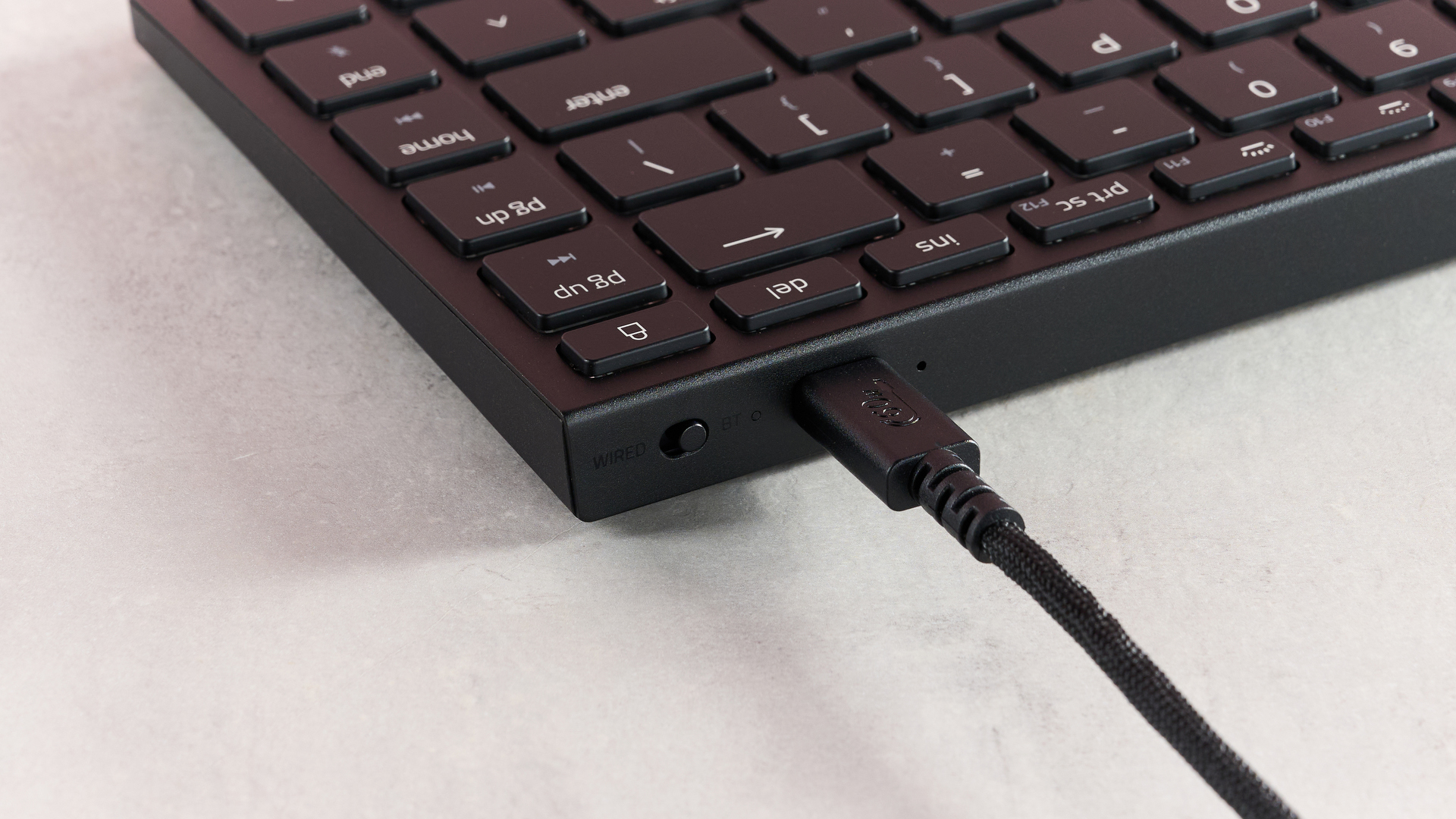 Close-up of USB cable coming out of Razer Joro on desk