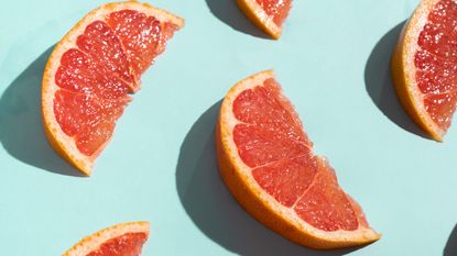 Grapefruit Slices On Turquoise Background - stock photo