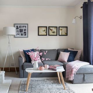 living room with white wall grey floor mat and grey sofa set