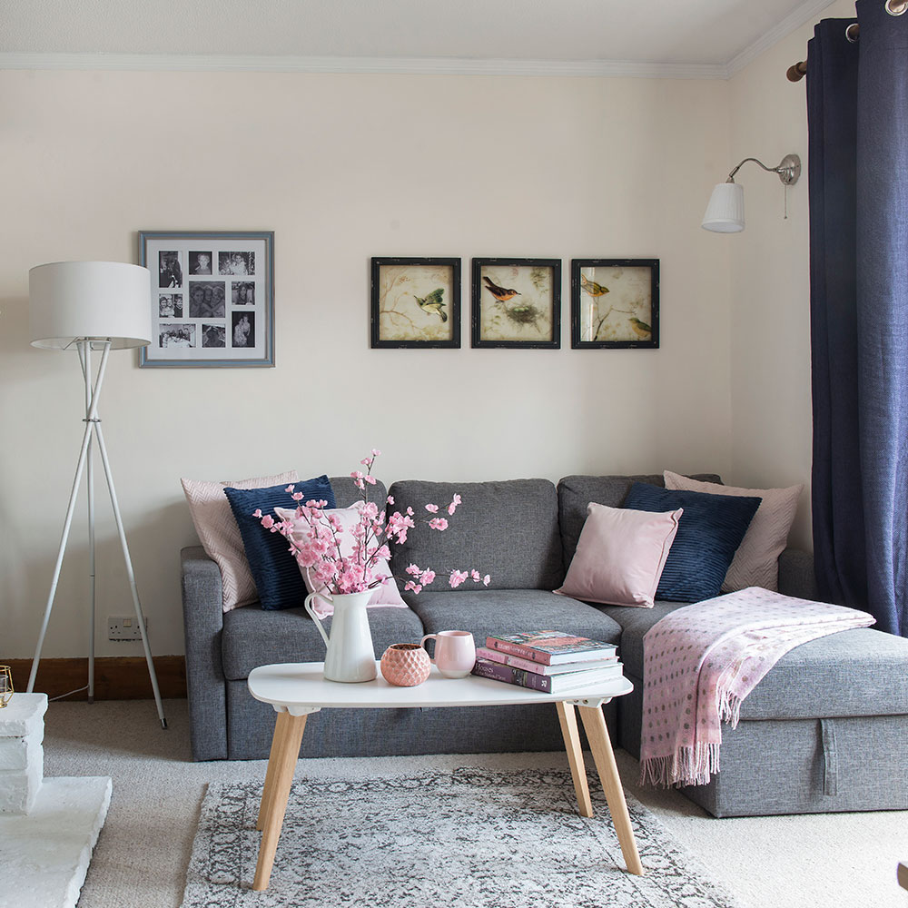 living room with white wall grey floor mat and grey sofa set