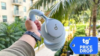 Soundcore Space One held in hand in front of palm tree