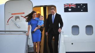 Prince William and Kate Middleton, holding Prince George, disembark a plane as they arrive at Defence Establishment Fairbairn in Canberra on April 20, 2014