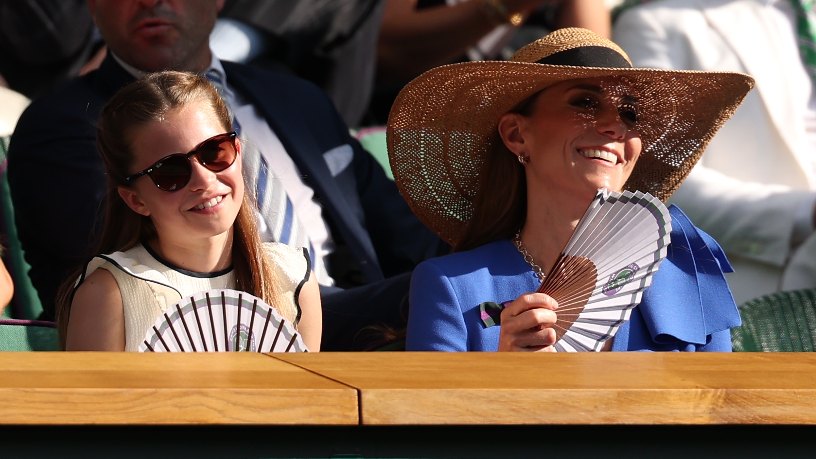 Princess Charlotte and Catherine, Princess of Wales fan themselves in the Royal Box during the Wimbledon Gentleman's Singles Final on July 13, 2025