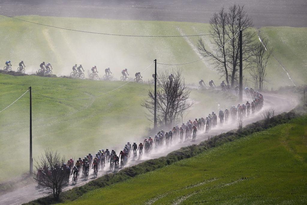 The Strade Bianche peloton lined out in the dust
