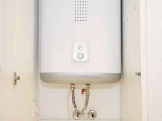 A gas boiler inside a small room with white walls