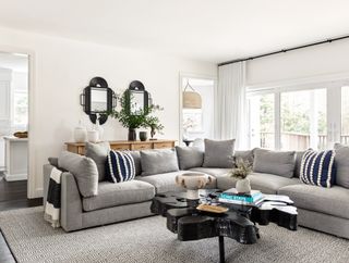 a light grey couch with patterned pillows