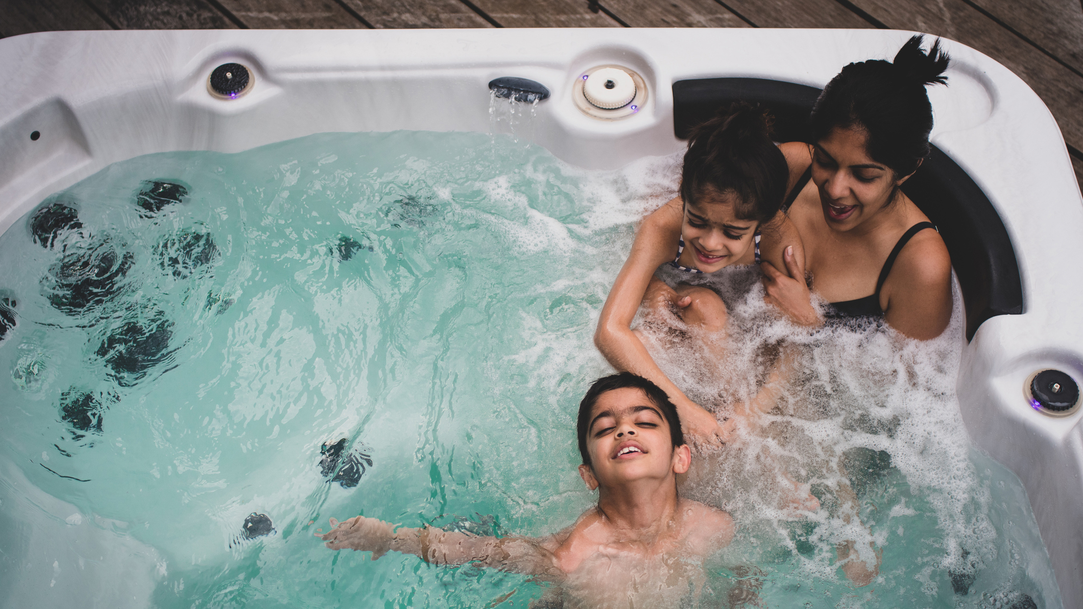 Best hot tubs: A woman and her two young children have fun in their new hot tub