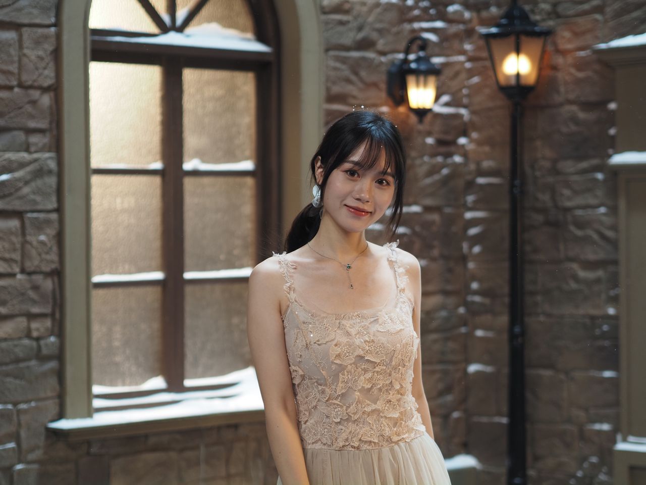 OM System PEN sample gallery: Female model in lace dress, there's a snowy old town studio backdrop