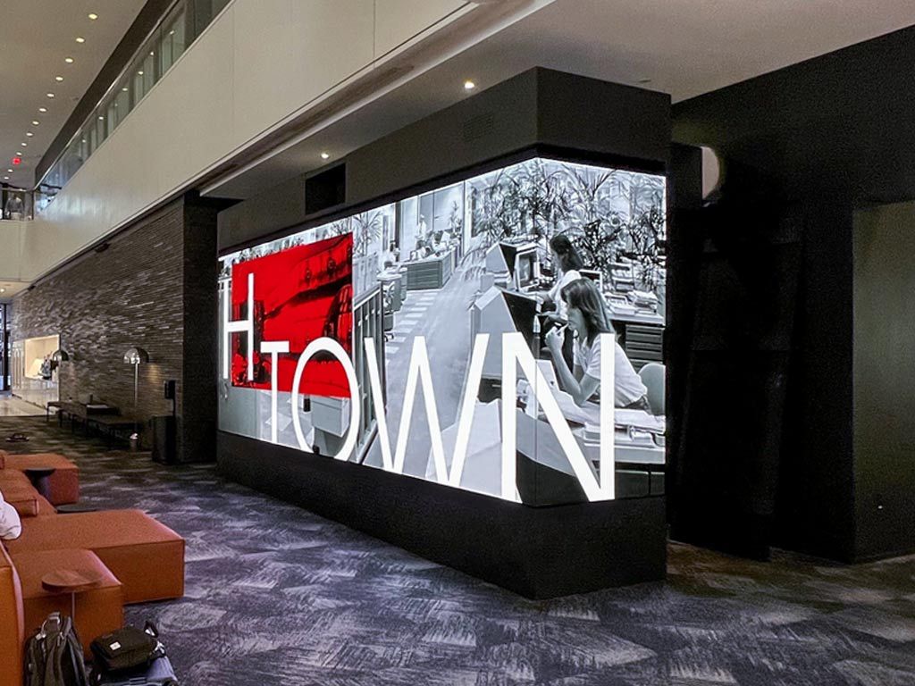 A massive LED display showing Houston landscape in an office building.