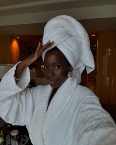 Woman wearing white dressing gown and hair towel