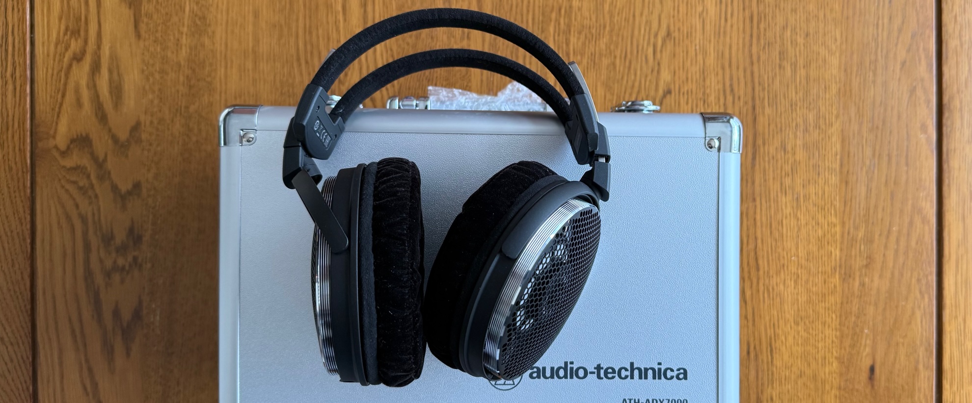 Photos of the Audio-Technica ATH-ADX7000 headphones on a wooden table