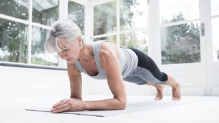A woman doing a plank on her forearms