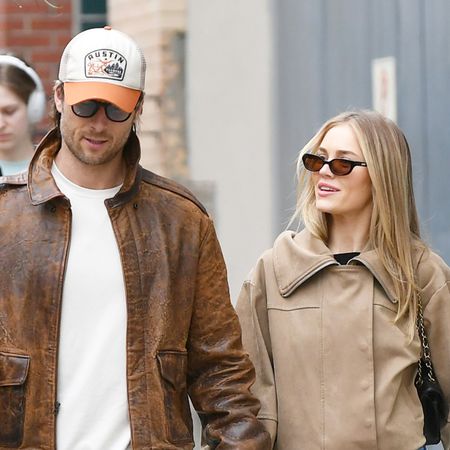 Glen Powell and Michelle Randolph walking in NYC wearing tan jackets and jeans