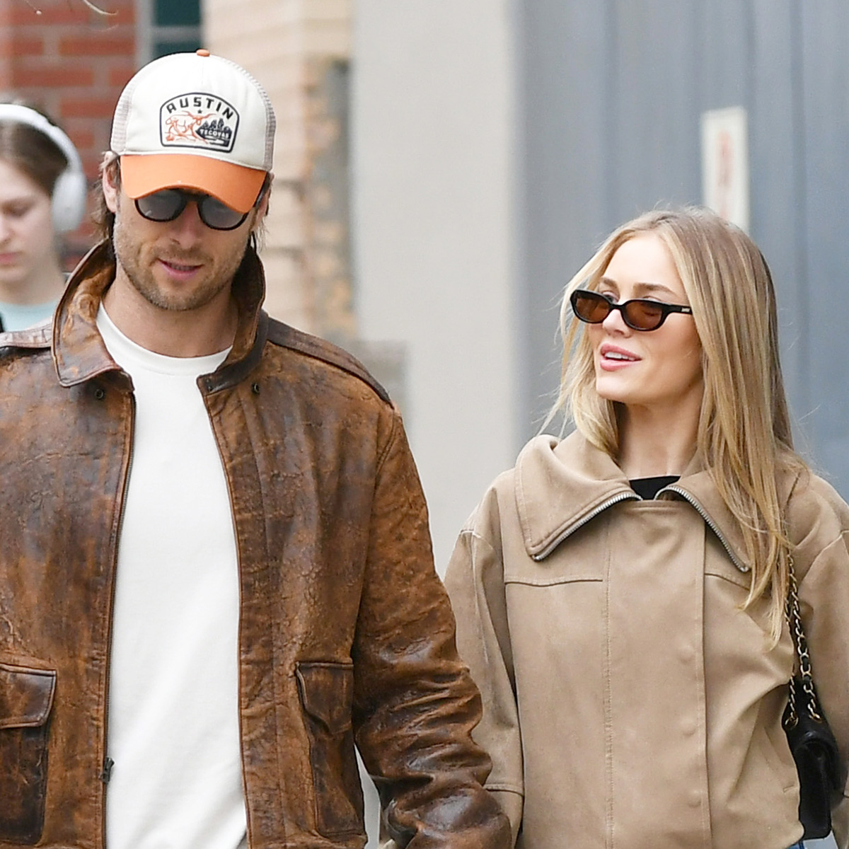 Glen Powell and Michelle Randolph walking in NYC wearing tan jackets and jeans