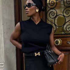 Woman wears black vest, black bag