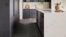 Modern kitchen with Verona Quartzite luxury vinyl tile flooring with grey cabinetry, white marble countertop and backsplash