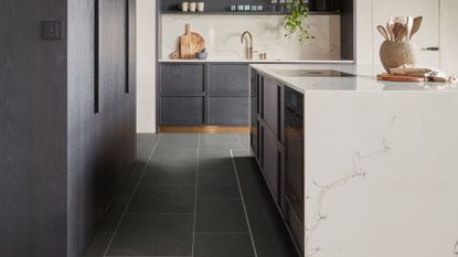 Modern kitchen with Verona Quartzite luxury vinyl tile flooring with grey cabinetry, white marble countertop and backsplash